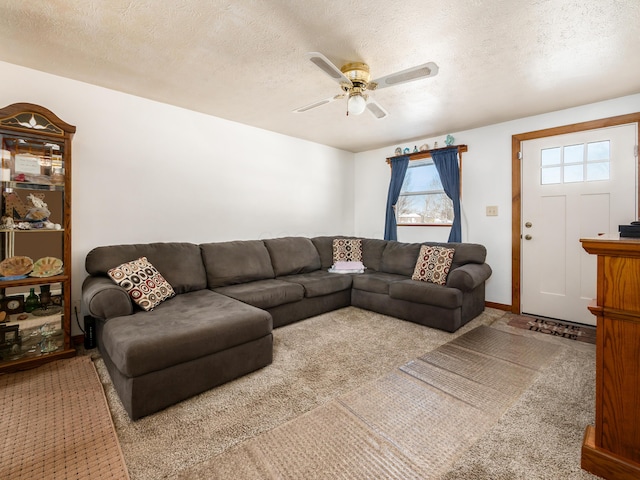 carpeted living room featuring ceiling fan and a textured ceiling