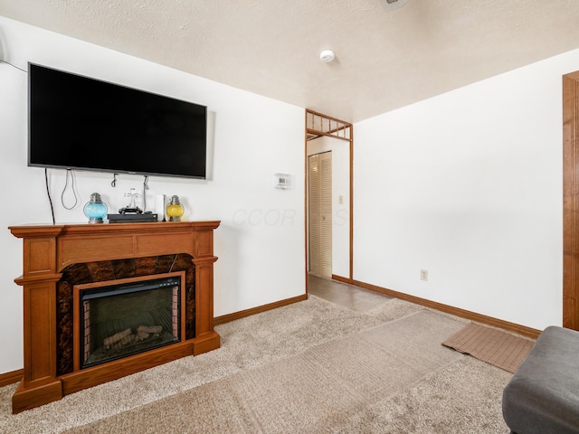 carpeted living room with a high end fireplace and a textured ceiling