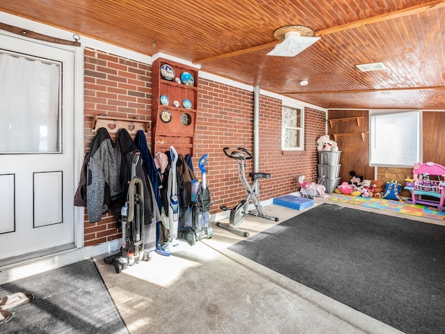 interior space with wooden ceiling, carpet, and brick wall