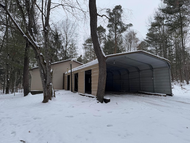 view of snow covered exterior featuring a carport