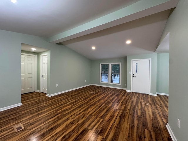 empty room with vaulted ceiling with beams and dark hardwood / wood-style floors