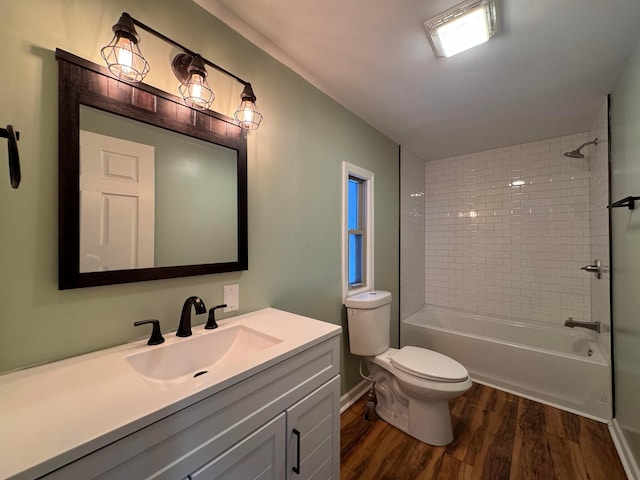 full bathroom with toilet, hardwood / wood-style floors, vanity, and tiled shower / bath combo