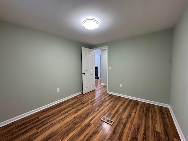 spare room with dark hardwood / wood-style floors