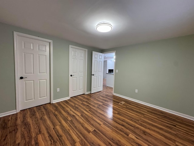 unfurnished bedroom with dark wood-type flooring