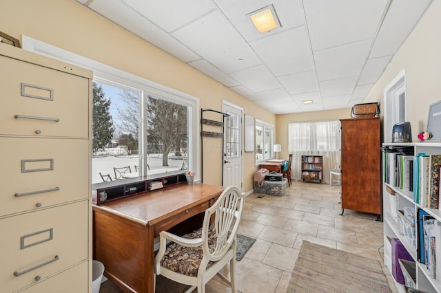 tiled home office featuring a paneled ceiling