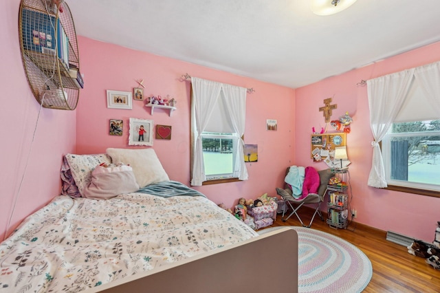 bedroom featuring hardwood / wood-style floors and multiple windows