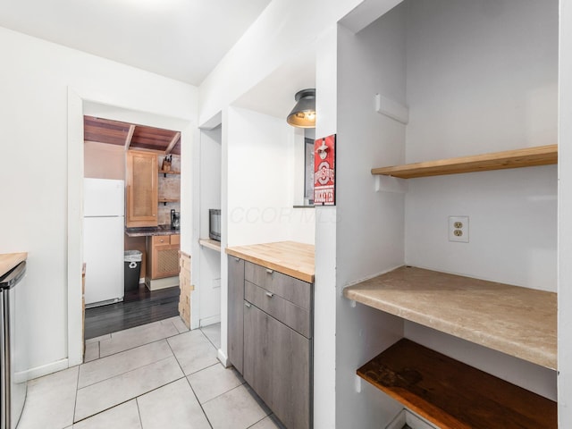 kitchen with white refrigerator and light tile patterned floors