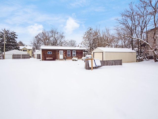 snow covered property with an outbuilding and a garage