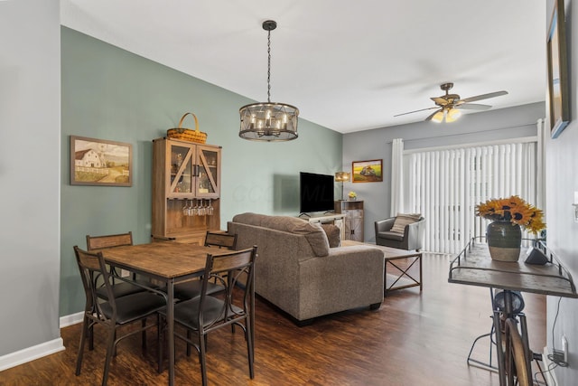 living room with ceiling fan with notable chandelier and dark hardwood / wood-style floors