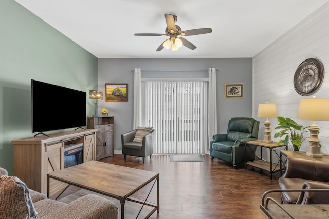 living room featuring ceiling fan and dark hardwood / wood-style flooring