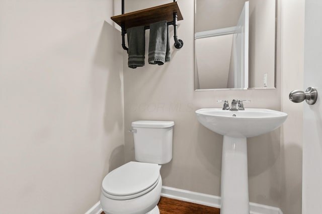 bathroom with toilet, hardwood / wood-style flooring, and sink