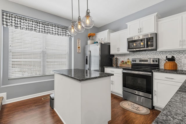 kitchen featuring white cabinets, decorative backsplash, dark stone counters, and stainless steel appliances