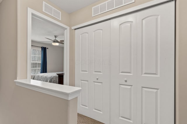 hallway with a textured ceiling and carpet flooring