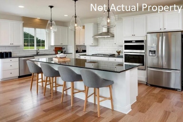 kitchen featuring sink, a center island, pendant lighting, stainless steel appliances, and white cabinets