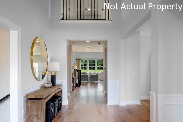 hallway featuring hardwood / wood-style flooring and a towering ceiling