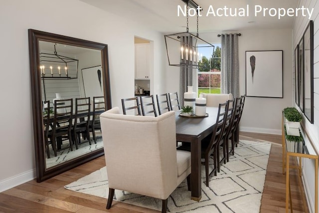 dining room with light hardwood / wood-style flooring and a chandelier