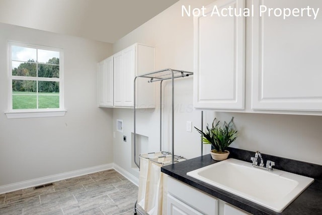 laundry room with cabinets, hookup for an electric dryer, hookup for a washing machine, and sink