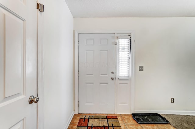 tiled foyer entrance with baseboards