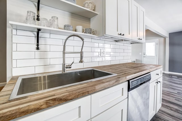 kitchen with dishwasher, butcher block counters, sink, and white cabinetry