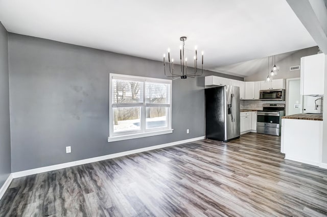 kitchen with wood-type flooring, white cabinetry, butcher block counters, stainless steel appliances, and tasteful backsplash