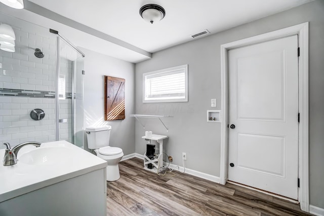 bathroom with an enclosed shower, vanity, toilet, and hardwood / wood-style floors