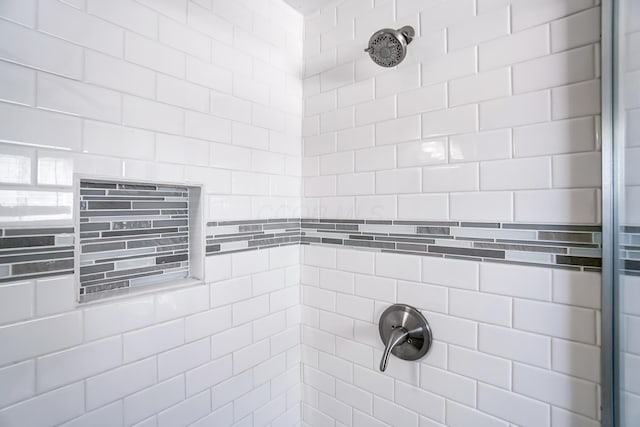 interior details with a tile shower