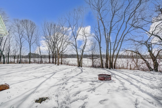 yard layered in snow featuring an outdoor fire pit