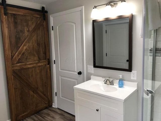 bathroom with a shower, hardwood / wood-style floors, and vanity