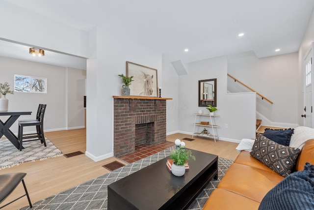 living room with hardwood / wood-style flooring and a brick fireplace