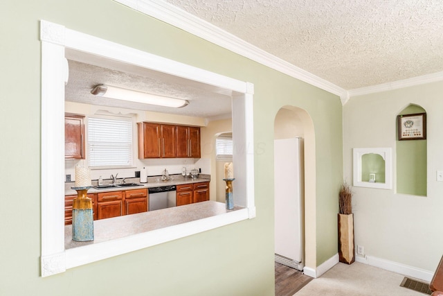 kitchen featuring dishwasher, sink, ornamental molding, and a textured ceiling