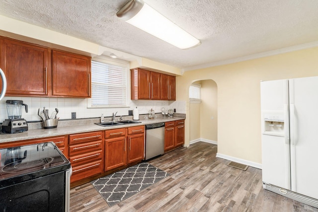 kitchen featuring a textured ceiling, dishwasher, white fridge with ice dispenser, and sink