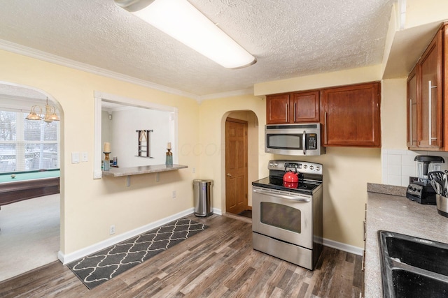 kitchen featuring sink, crown molding, a chandelier, a textured ceiling, and appliances with stainless steel finishes