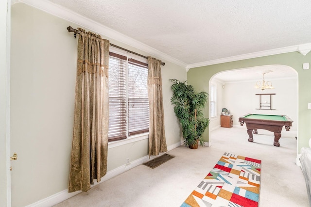 rec room with carpet, ornamental molding, a textured ceiling, a chandelier, and pool table