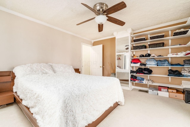 bedroom featuring carpet flooring, ceiling fan, crown molding, and a textured ceiling