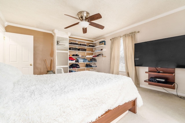 carpeted bedroom with a textured ceiling, ceiling fan, and ornamental molding