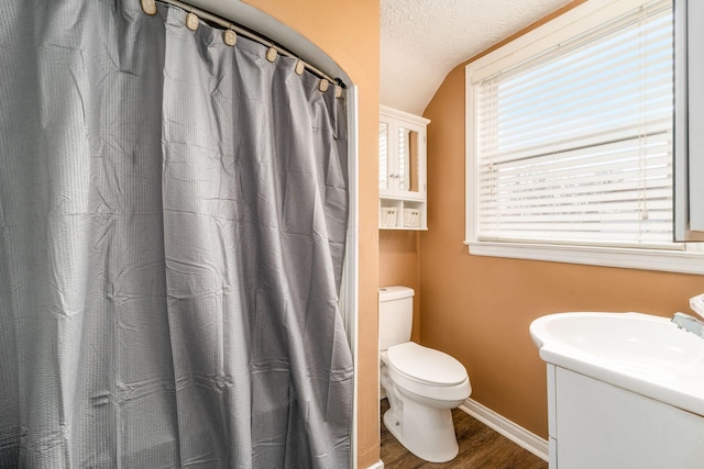 bathroom featuring sink, a textured ceiling, toilet, lofted ceiling, and hardwood / wood-style flooring