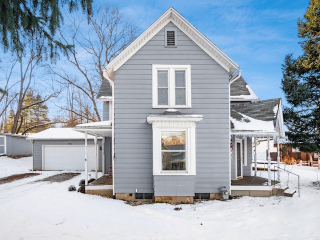 view of front of home featuring a garage and an outbuilding