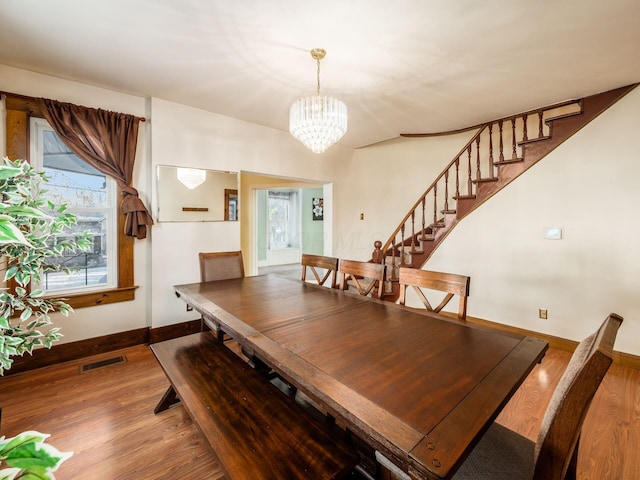 dining area featuring hardwood / wood-style floors and a chandelier