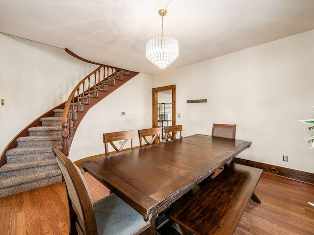 dining room with wood-type flooring and a notable chandelier