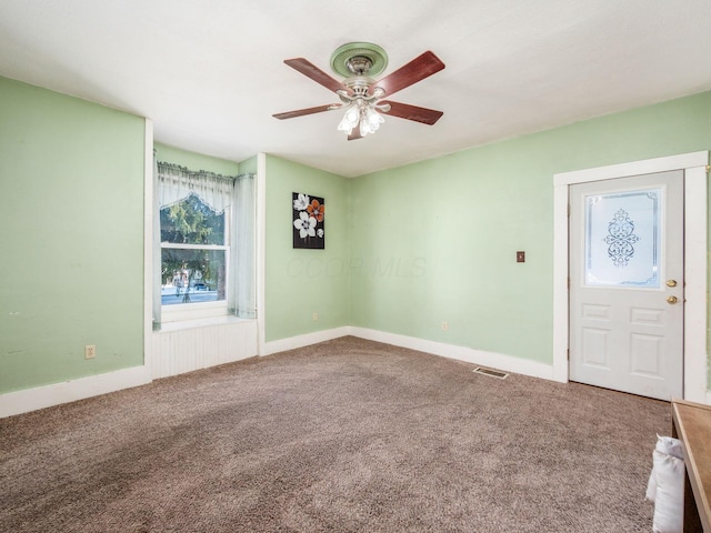 entryway with ceiling fan and carpet