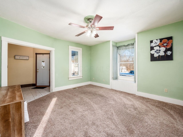 carpeted spare room featuring ceiling fan