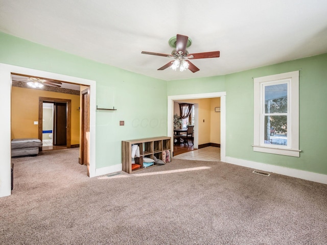 spare room featuring light carpet and ceiling fan