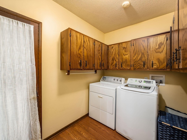 laundry room featuring independent washer and dryer, cabinets, a textured ceiling, and dark hardwood / wood-style floors