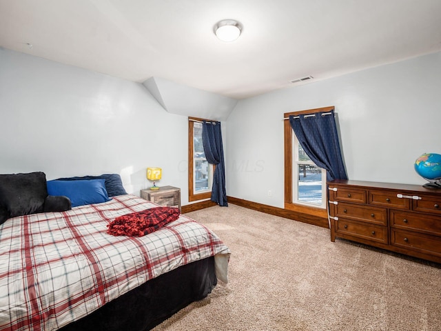 bedroom with light colored carpet and lofted ceiling