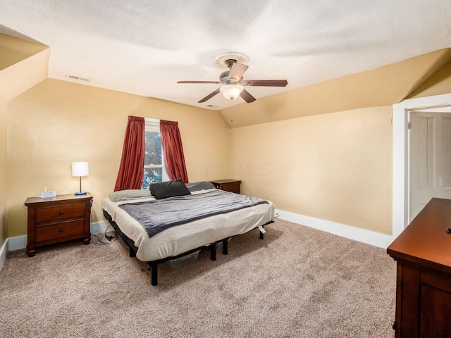 carpeted bedroom featuring ceiling fan, vaulted ceiling, and a textured ceiling