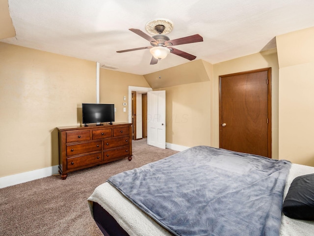 carpeted bedroom with ceiling fan, a closet, and vaulted ceiling