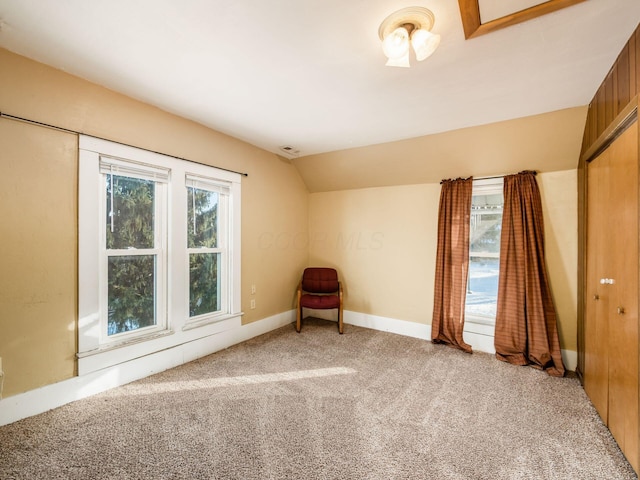 unfurnished room featuring vaulted ceiling and light colored carpet