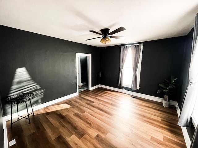 unfurnished room with ceiling fan and wood-type flooring