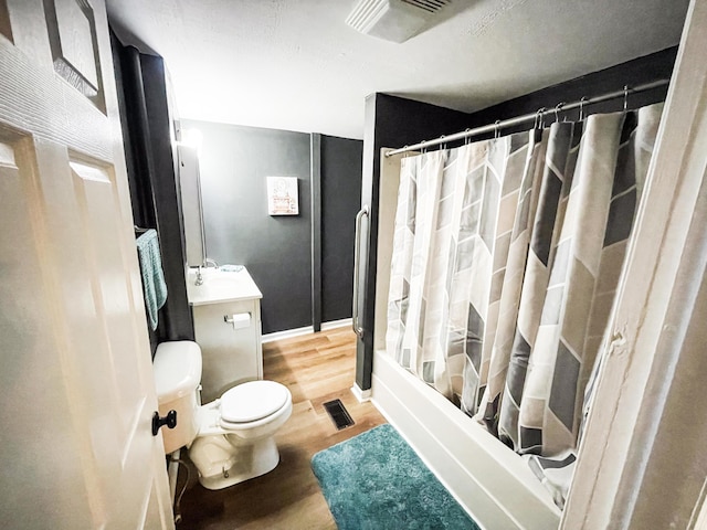 full bathroom with hardwood / wood-style floors, vanity, toilet, and shower / bath combination with curtain