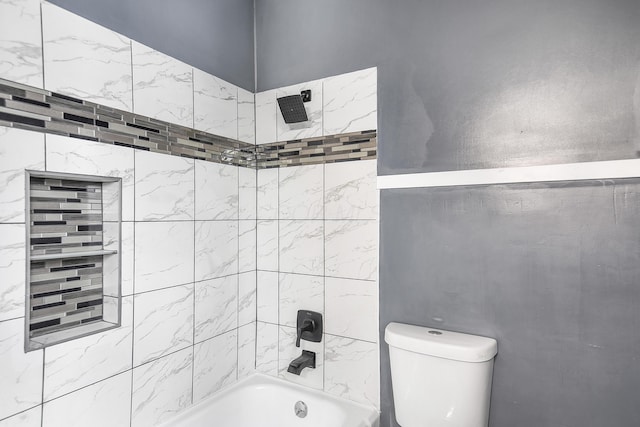 bathroom with tiled shower / bath combo and toilet